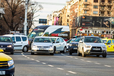 Traffic on road by buildings in city