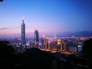 Illuminated cityscape against sky at night