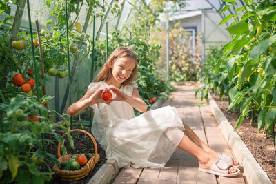 Portrait of young woman picking apples