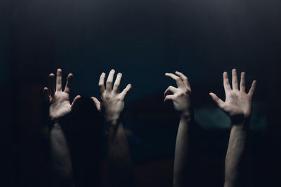 Cropped hands of people gesturing in darkroom