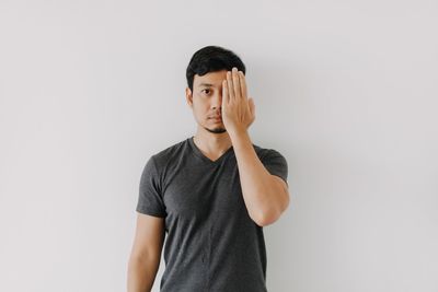 Young man standing against white background