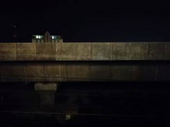 Bridge over illuminated buildings in city at night