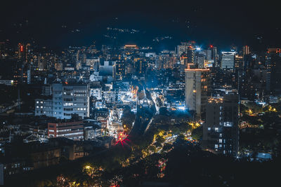 High angle view of illuminated buildings in city at night