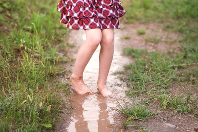 Low section of woman walking on field