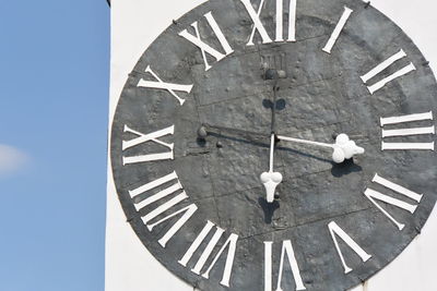 Low angle view of clock on building against sky