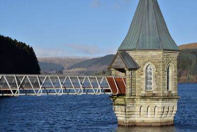 Gazebo by water against sky