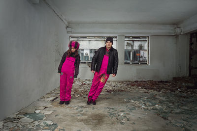 Portrait of couple wearing warm clothing while standing in abandoned house