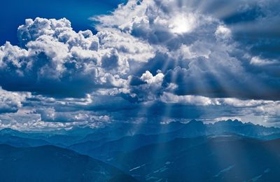 Aerial view of mountains against blue sky