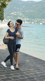 Cheerful couple walking on promenade