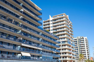 Low angle view of modern buildings against clear blue sky