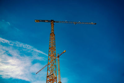 Low angle view of crane against blue sky