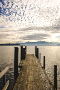 Wooden pier over sea against sky