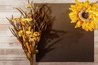 High angle view of yellow flower with brown paper on table