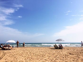 People on beach against sky