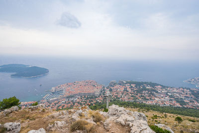 High angle view of sea and cityscape against sky