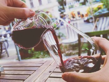 Close-up of pouring wine into glass outdoors