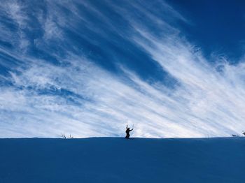 Man on snowcapped mountain against blue sky