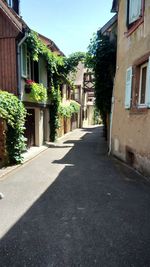 Empty road amidst buildings against sky