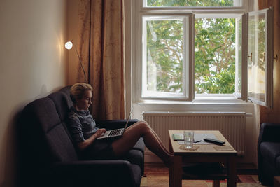 Woman using laptop in living room