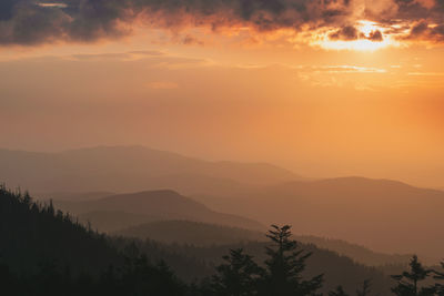 Scenic view of silhouette mountains against orange sky