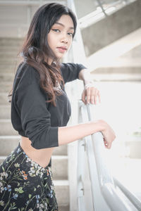 Side view of young woman standing by water