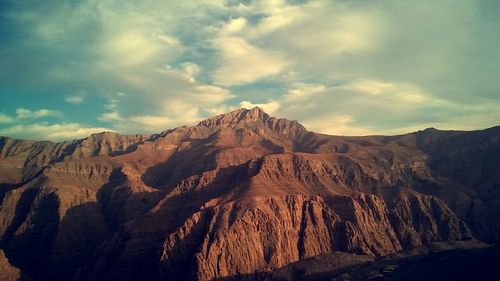 Scenic view of mountains against cloudy sky