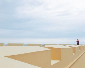 Woman standing on beach against sky