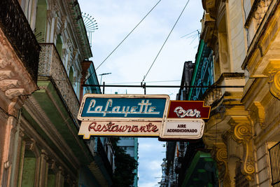 Low angle view of road sign against buildings in city