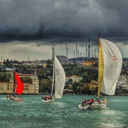 Boat sailing in sea against cloudy sky