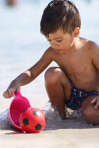 Boy playing soccer at beach