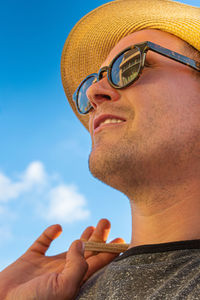 Low angle view of man wearing sunglasses against sky