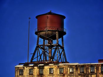 Low angle view of water tower against blue sky