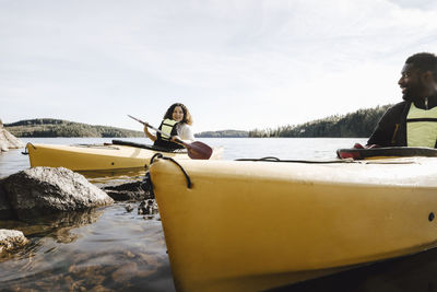 Woman talking with boyfriend while kayaking on lake