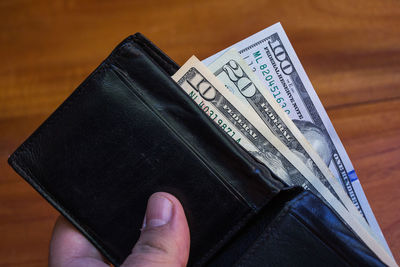 Close-up of hand holding book on table