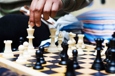 Cropped hand of man playing chess