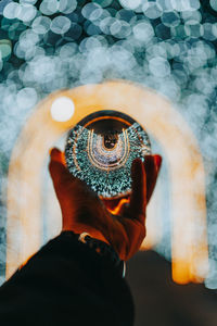 Close-up of persons band holding a lensball 