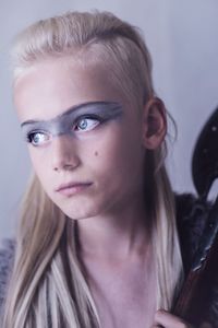 Close-up of cute girl with eye make-up at home