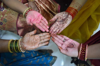 Cropped hands of women in henna tattoo