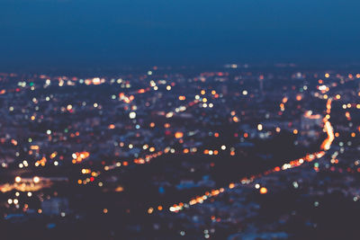 Aerial view of illuminated cityscape against sky at night