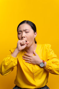 Portrait of a beautiful young woman over yellow background