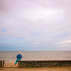 Rear view of woman looking at sea against sky