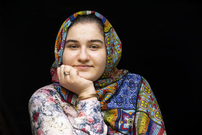 Portrait of a teenage beautiful girl with colorful clothes in front of black background