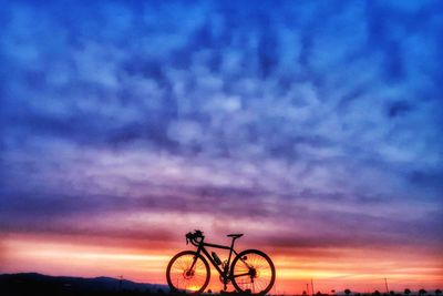 Silhouette bicycle against sky at sunset