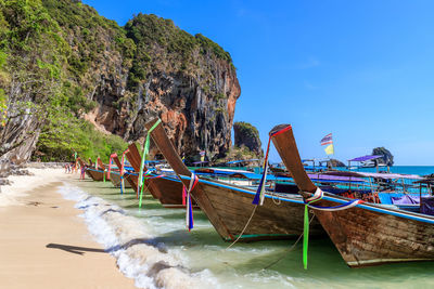 Boats moored on beach against sky