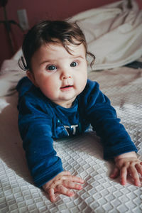 Close-up of baby girl on bed