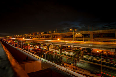 Light trails on street against sky at night