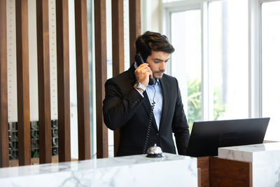 Mid adult man using mobile phone at home