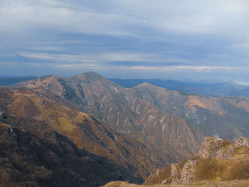 Scenic view of mountains against cloudy sky