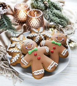 Christmas gingerbread in the plate and candles on white wooden background. top view.