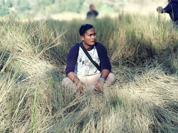 Young man looking away on field